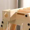 A close-up view of a wooden indoor climbing frame, showing details of its construction and a brand logo. Produktbild-Vorschau
