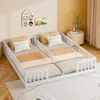 Two children's beds with white railings are set up side-by-side in a room with light-colored walls and wooden flooring. Decorative wall art and a small side table with a plant are visible. Náhľad obrázku produktu