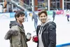 Two men are standing on an ice rink, holding coffee cups. Produktbild-Vorschau