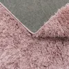 Close-up view of the underside and fluffy texture of a pink rug. Produktbild-Vorschau