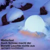 A glowing sphere light sits in the snow, surrounded by rocks and snow-covered ground. Produktbild-Vorschau