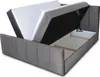A grey upholstered bed frame with the mattress lifted to reveal the storage compartment underneath. Produktbild-Vorschau