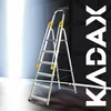 A silver aluminum ladder with yellow accents is shown in a warehouse-like setting. Náhled obrázku produktu