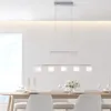 A modern dining room setting with a table, chairs, and a pendant light. Produktbild-Vorschau