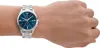 A person's wrist wearing a silver watch with a blue dial. Produktbild-Vorschau