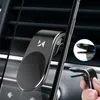 A magnetic phone holder attached to a car's air vent, with a smartphone mounted on it. Voir les images du produit