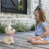 A young girl sits on a wooden deck, looking at a stuffed dog. Anteprima dell’immagine prodotto