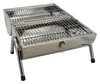A stainless steel charcoal grill with two grates and foldable legs, shown from a slightly elevated front-diagonal angle against a white background. Náhled obrázku produktu