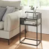 A modern black metal side table next to a light-colored sofa in a living room setting. Anteprima dell’immagine prodotto