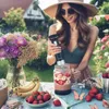 A woman is making a smoothie in a garden setting. Produktbild-Vorschau