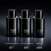 Three black bottles of Armani Code perfume are displayed on a dark, reflective surface with a dark background. Voir les images du produit