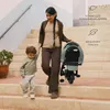 A woman and a child are walking down stairs with a folded stroller. Voir les images du produit