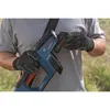 A person wearing gloves is holding a Bosch battery-powered string trimmer and attaching a battery. Voir les images du produit
