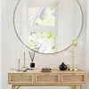 A console table with decorative items in front of a large round mirror. Anteprima dell’immagine prodotto