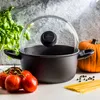 A cooking pot with a glass lid, surrounded by fresh ingredients like tomatoes, basil, spaghetti, peppercorns, and a pumpkin. Náhled obrázku produktu