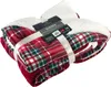 A folded plaid Sherpa blanket tied with a ribbon, with a product tag attached. Produktbild-Vorschau