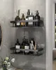 Two black shower shelves mounted on a gray tiled wall, filled with various toiletries and bathroom accessories. Produktbild-Vorschau