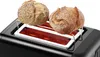 A close-up shot of a black toaster with two bread rolls on a warming rack. Produktbild-Vorschau