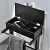 A black valet stand with its lid open, showing compartments for a phone, watch, and other accessories. A white shirt is draped over the back, and gray trousers are hanging from the bottom bar. Produktbild-Vorschau