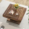 A square wooden coffee table with a floral arrangement, magazines, and a cup of coffee on it, placed on a light gray rug. Anteprima dell’immagine prodotto
