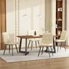A dining table with four chairs in a well-lit room. Produktbild-Vorschau
