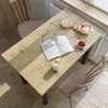 A dining table set up for breakfast with a book and coffee. Produktbild-Vorschau