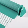 A close-up view of a teal roller blind mechanism and fabric. Produktbild-Vorschau