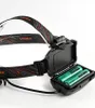 A close-up view of a black headlamp with its battery compartment open, revealing two green batteries. Podgląd zdjęcia produktu