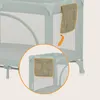 A close-up view of a travel crib with a storage pocket attached to the side, with an inset showing a detailed view of the pocket. Náhľad obrázku produktu