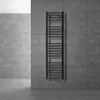 A black radiator mounted on a gray tiled wall in a bathroom. Náhled obrázku produktu