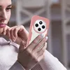 A woman is holding a pink and white phone case with a Xiaomi Redmi 14C phone inside. Produktbild-Vorschau