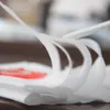 A close-up of white vacuum cleaner bags, with some red elements visible underneath. Náhled obrázku produktu