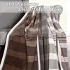 A striped blanket draped over a chair. Produktbild-Vorschau