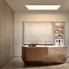 A modern kitchen with a wooden island and white cabinets, illuminated by a ceiling light. Anteprima dell’immagine prodotto