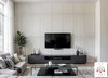 A modern living room with a large TV mounted on a paneled wall, a sofa, and a coffee table. Produktbild-Vorschau