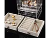 A jewelry organizer box with several drawers and a clear acrylic display case filled with jewelry. Produktbild-Vorschau