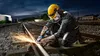 A worker in protective gear is grinding a railway track at night, with sparks flying. Náhľad obrázku produktu