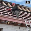 A roofer is working on a roof, installing underlayment. Produktbild-Vorschau