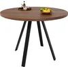A round dining table with a wooden top and black metal legs, set against a white background. There are some decorative items on the table. Anteprima dell’immagine prodotto