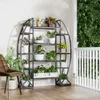 A circular plant stand filled with various plants is placed on a balcony next to a chair. Podgląd zdjęcia produktu