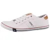 A white low-top sneaker with brown accents and blue and red trim. Produktbild-Vorschau