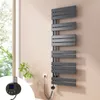 A modern, dark gray electric towel radiator is mounted on a light pink wall next to a window with greenery visible outside. A close-up inset shows the digital controller with temperature display. Voir les images du produit