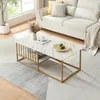 A coffee table with a marble-like top and gold-colored legs is placed in a living room setting next to a sofa. Náhľad obrázku produktu