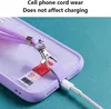 Close-up of a phone case with a lanyard attached, showing a charging cable plugged in. Podgląd zdjęcia produktu