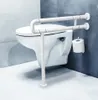 A white U-shaped grab bar is installed next to a toilet in a bathroom. A roll of toilet paper is mounted on the wall to the right of the grab bar. Náhľad obrázku produktu