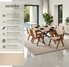 A dining room with a table and chairs, set up for a meal, with a pool visible through large windows. Produktbild-Vorschau