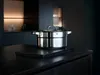A stainless steel pot with a lid sits on a dark countertop in a modern kitchen. Produktbild-Vorschau