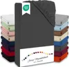 A stack of folded fitted sheets in various colors, with a dark gray fitted sheet prominently displayed in the foreground. Produktbild-Vorschau