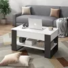 A modern living room scene with a grey sofa, a coffee table with a laptop, and decorative pillows on the floor. Voir les images du produit