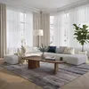 A modern living room with a sectional sofa, coffee table, rug, and large windows with sheer curtains. Voir les images du produit